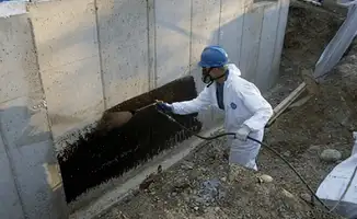 Professional waterproofing the exterior walls of the basement in Riverside, CA