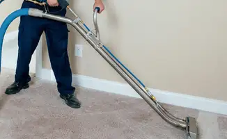 Professional operating a liquid removal machine on a carpeted floor in Riverside, CA